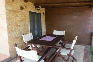 a wooden table and chairs on a patio at Bambola Apartments in Nea Moudania +22 photos