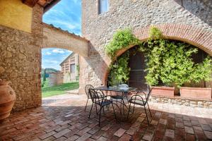 a patio with a table and chairs in a building at Agriturismo Poggio Bonelli in Castelnuovo Berardenga