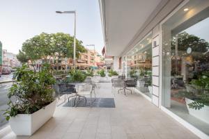 una tienda con mesas, sillas y plantas en Planet One Hotel, en El Arenal