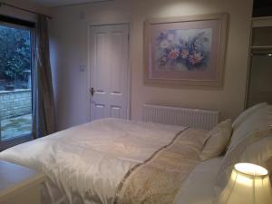 a bedroom with a white bed and a window at Sunny Patch in Stroud