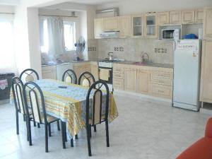 eine Küche mit einem Tisch mit Stühlen und einem Kühlschrank in der Unterkunft Departamentos Santa Monica in Puerto Madryn