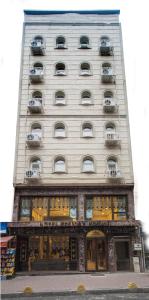 イスタンブールにあるPelican House Hotelの窓とバルコニーが備わる高い白い建物です。