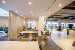 an office lobby with tables and chairs and a cafeteria at Planet One Hotel in El Arenal