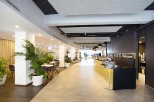 eine Lobby eines Restaurants mit Tischen und Topfpflanzen in der Unterkunft Planet Hotels ONE - Adults Only 16 years in El Arenal + 37 Fotos
