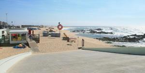 a sandy beach with a stop sign and the ocean at Apartamento Soares in Vila do Conde