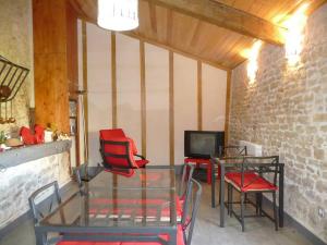 Zimmer mit 2 Tischen und Stühlen sowie einem TV in der Unterkunft Le Haut Fontaine : minis maisons de charme in Saint-Georges-lès-Baillargeaux