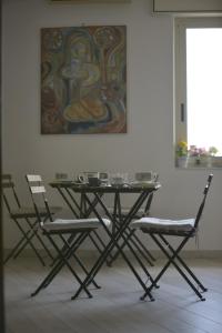 ポンペイにあるB & B VICTORIAの絵画のある部屋のテーブルと椅子