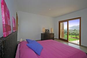 a bedroom with a purple bed and a large window at Santa Maria in Alcudia