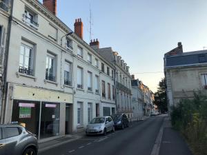 una calle con edificios y coches estacionados en la calle en Le 24 Clemenceau, en Châtellerault