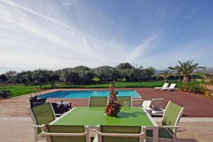 a patio with a table and chairs and a pool at Santa Maria in Alcudia