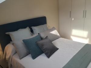 a bed with several pillows on it in a room at Ático Jaca Ciudadela in Jaca