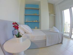 una camera da letto con un letto e un tavolo con un vaso di fiori di Paliouri Sea Lounge by Luxlikehome a Paliouri