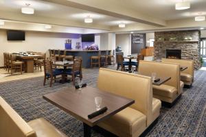a restaurant with tables and chairs and a fireplace at Radisson Hotel Ames Conference Center at ISU in Ames