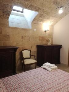 a bedroom with a bed and a chair and a skylight at Corte Della Luna in Acquarica del Capo