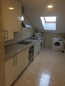 a kitchen with a sink and a washing machine at Ático Jaca Ciudadela in Jaca +7 photos