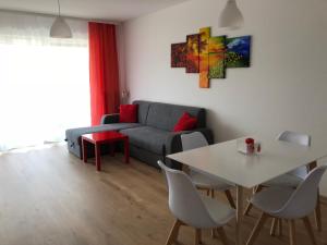 a living room with a couch and a table at Apartament W KWIATKI:) Pogorzelica in Pogorzelica