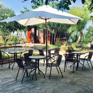 a group of tables and chairs under an umbrella at Bed & Breakfast "Camera a Sud" in Cariati