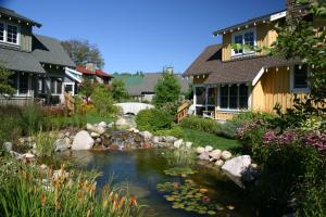 einen Garten mit einem Teich vor den Häusern in der Unterkunft Crystal Mountain in Thompsonville