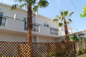two palm trees in front of a building at Bel Momento in Alikanas
