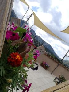 a bunch of flowers on a balcony with mountains in the background at Antico Borgo in Ovindoli