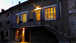 a building with a staircase and windows and a balcony at Le ciel par-dessus le toit in Salavas