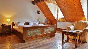 a bedroom with a bed and a chair at Hotel Restaurant Mönchhof in Gaggenau