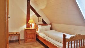 a small attic bedroom with a bed and a lamp at Hotel Restaurant Mönchhof in Gaggenau