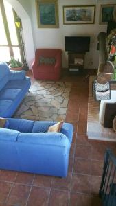 Massama的住宿－Affittacamere Luti，客厅配有蓝色的沙发和红色的椅子