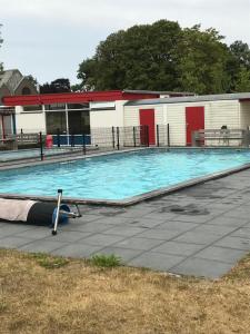 een groot zwembad voor een gebouw bij Vakantiehuis Tzummarum in Tzummarum