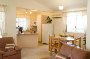 eine Küche und ein Wohnzimmer mit einem Tisch und einem Kühlschrank in der Unterkunft Glen Villa Resort in Byron Bay