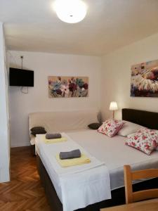 a bedroom with two beds and a flat screen tv at Apartments Iva und Franka in Omiš