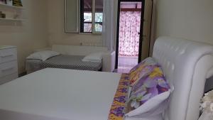 a living room with a white couch and a bedroom at B&B Villa Fanizza in Porto Cesareo