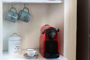 a red coffee maker and cups on a shelf at Apartment Florence with Love in Florence