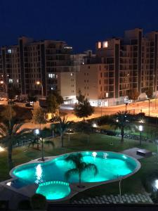 una gran piscina en un parque por la noche en New apartment in San Juan Playa, Alicante, en Alicante