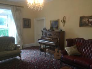 a living room with a piano and a couch at Hartley House B&B in Carrick on Shannon
