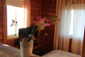 un jarrón con flores en él sentado en una mesa en Ananda, en Hararit