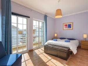 a bedroom with a bed and a large window at Holiday Home Grand Beach Hit by Interhome in Pêra