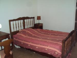 a bedroom with a bed and a table with a lamp at El gato negro in Montignac