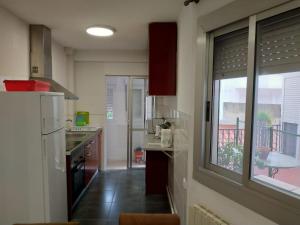 cocina con fregadero, ventana y encimera en apartamento Miñes en Zaragoza