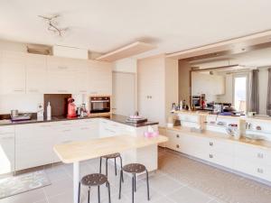 uma cozinha com armários brancos e uma mesa de madeira em Apartment Mas de la Madrague-10 by Interhome em La Madrague