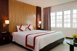a bedroom with a large bed and a large window at Petro House Vung Tau - Block B in Vung Tau