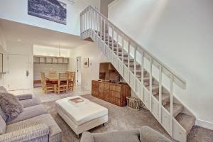 ein Wohnzimmer mit einer Treppe und einem Tisch in der Unterkunft Fp304 Foxpine Inn Condo in Copper Mountain