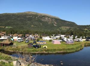 a small town with a lake and mountains at Granmo Camping in Oppdal