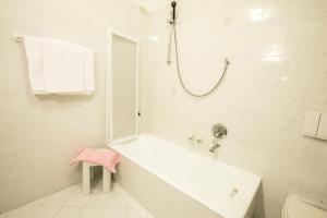 ein Bad mit einer Badewanne und einer Dusche mit einem Spiegel in der Unterkunft Albergo K2 in Madesimo