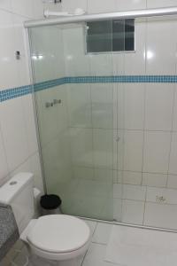 uma casa de banho com um WC e uma cabina de duche em vidro. em Pousada Santo André - O Apóstolo em Juazeiro do Norte