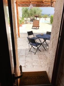 an open door to a patio with a table and chairs at Trulli Petra Chiara in Locorotondo
