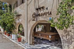 a stone building with a bench on a sidewalk at Philoxenia Apartments in Karpathos