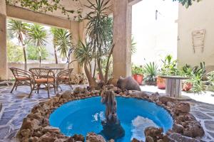 a pool in the middle of a patio with a bear fountain at Philoxenia Apartments in Karpathos