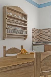 a kitchen with a table and a shelf with dishes at Philoxenia Apartments in Karpathos