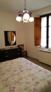 - une chambre avec un lit, une commode et un miroir dans l'établissement Locanda il Cacciatore, à Pari